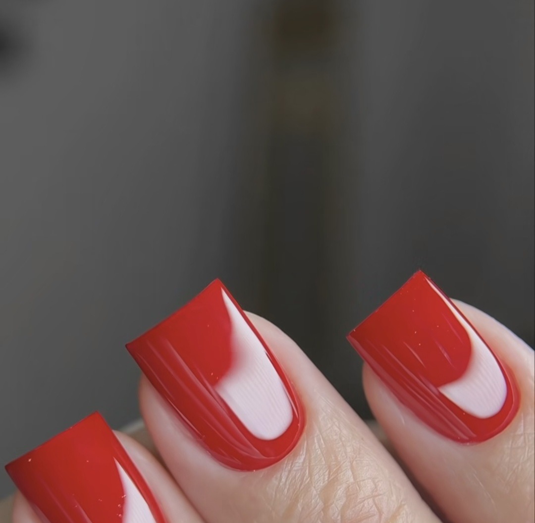 Vierkante nagels in kersenrood met een witte halve maan aan de nagelriem